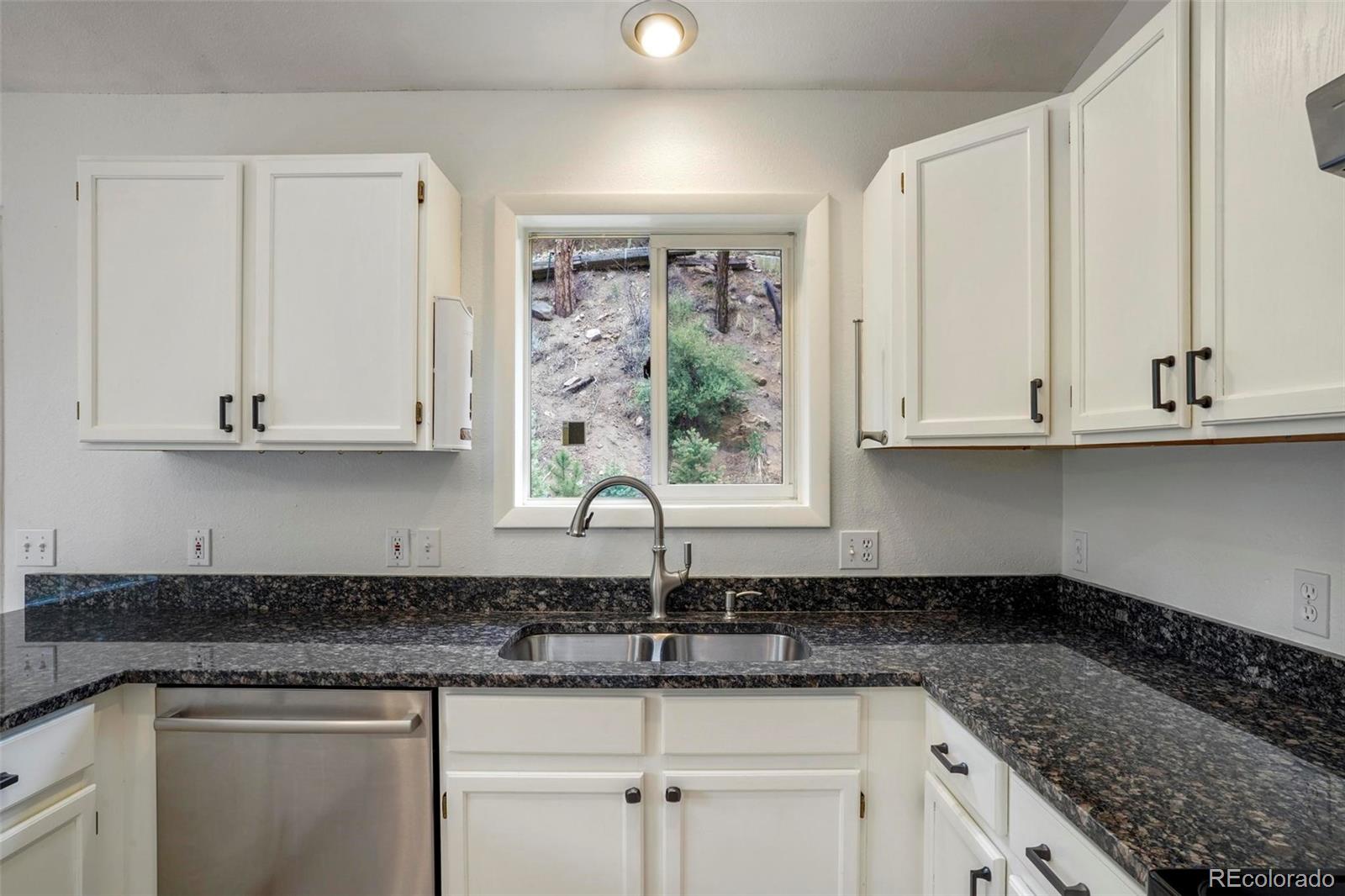 13519 Elsie Road Conifer, CO 80433 - Photo 8 of 31 a kitchen with granite countertop white cabinets and a sink