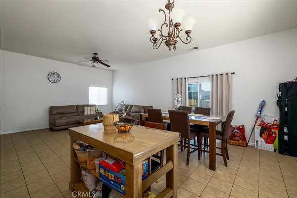 a kitchen with stainless steel appliances granite countertop a stove top oven a sink dishwasher a dining table and chairs with wooden floor