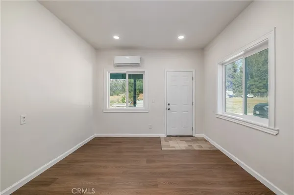 an empty room with wooden floor and a window