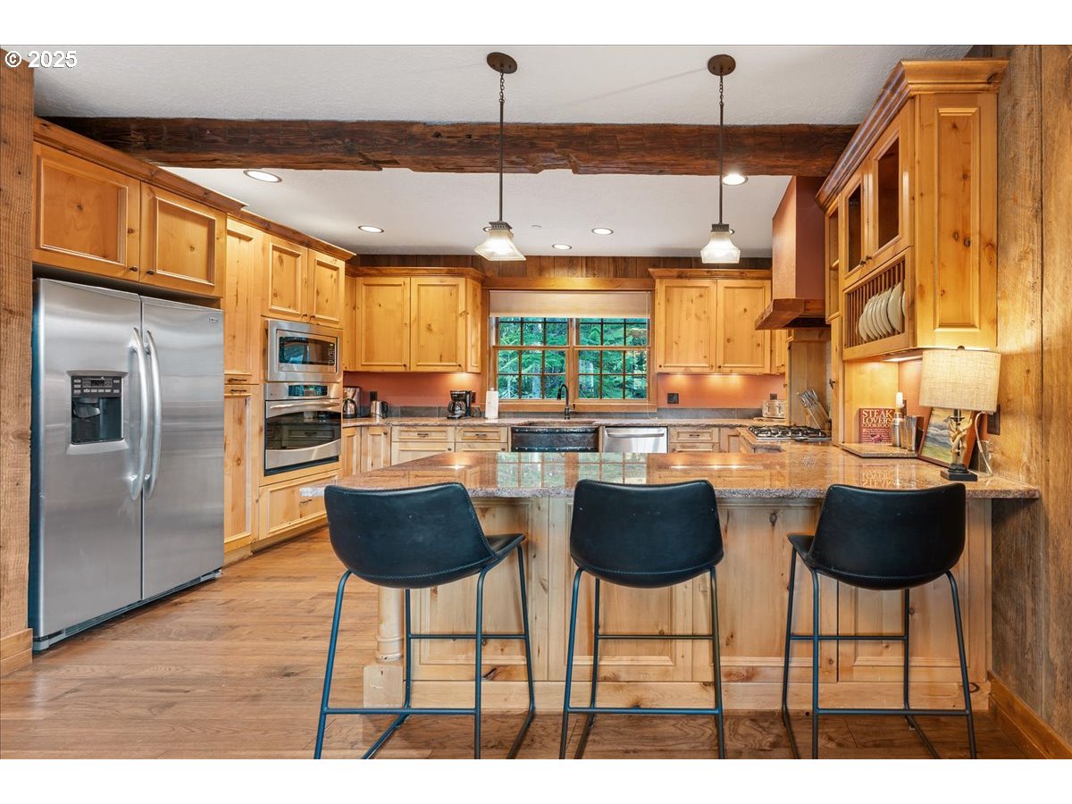 30930 Tyrolean Lane Government Camp, OR 97028 - Photo 15 of 42 a kitchen with stainless steel appliances kitchen island granite countertop a dining table chairs and a large window