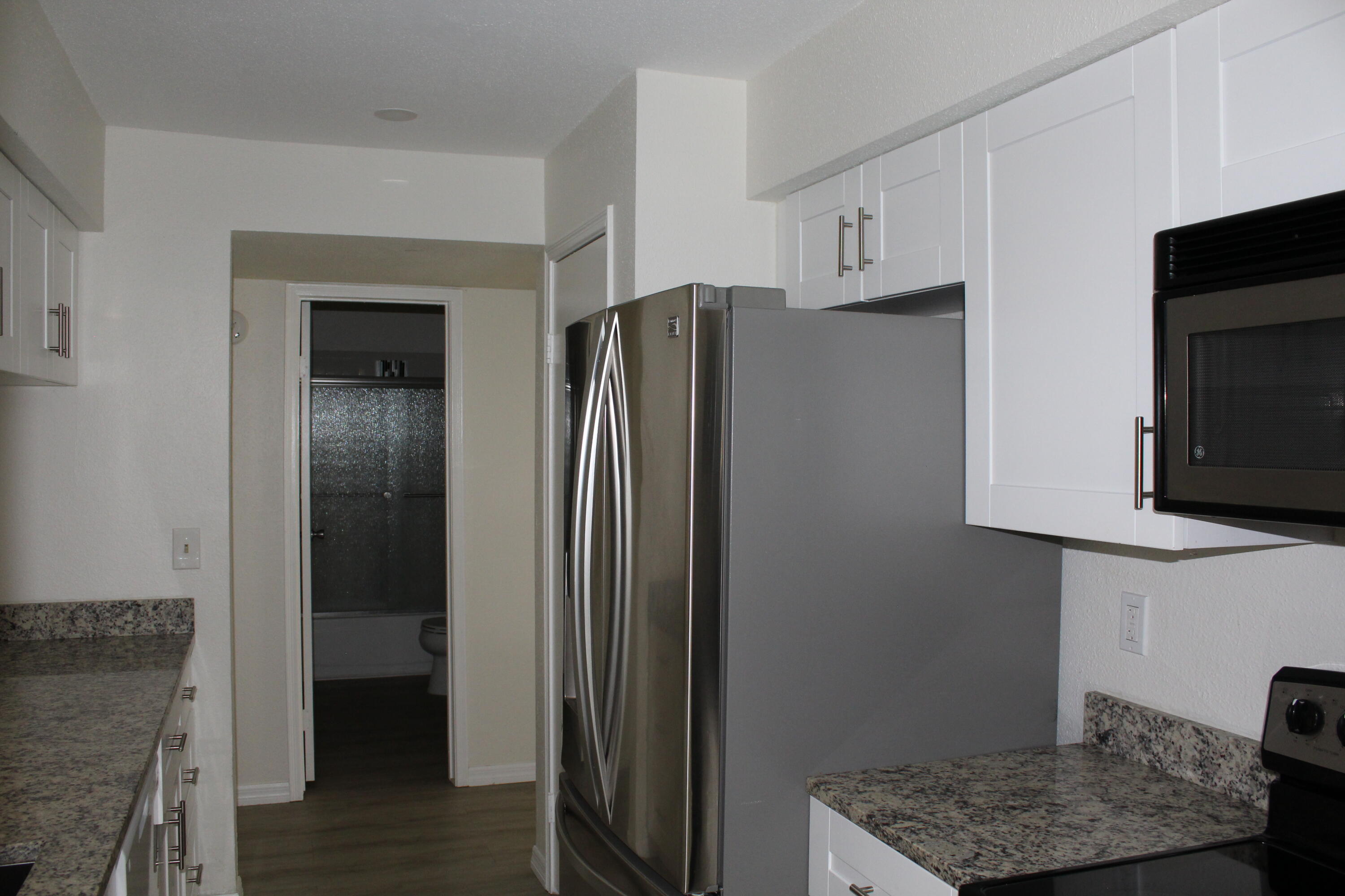 899 Riverside Drive, Unit 620 Coral Springs, FL 33071 - Photo 18 of 46 a kitchen with stainless steel appliances granite countertop a refrigerator and a stove top oven