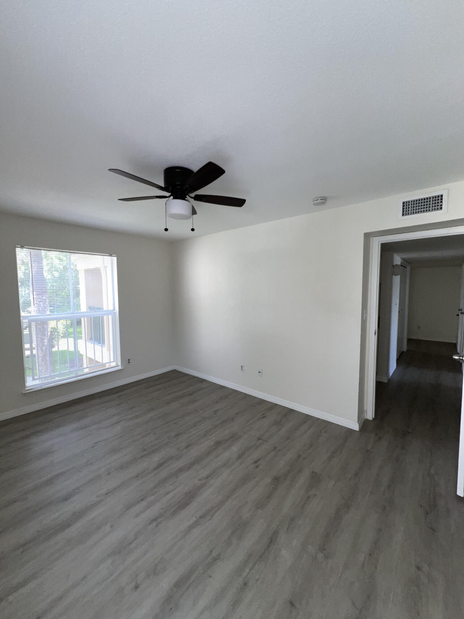 899 Riverside Drive, Unit 620 Coral Springs, FL 33071 - Photo 24 of 46 an empty room with wooden floor cabinet and windows