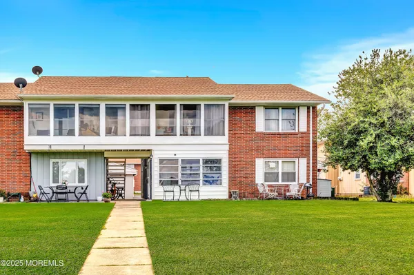 front view of a brick house with a yard