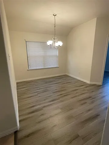 a view of a room with wooden floor and chandelier