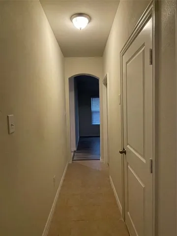 a view of a hallway with wooden shelves