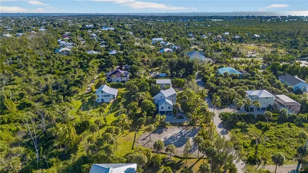 an aerial view of residential houses with outdoor space and trees