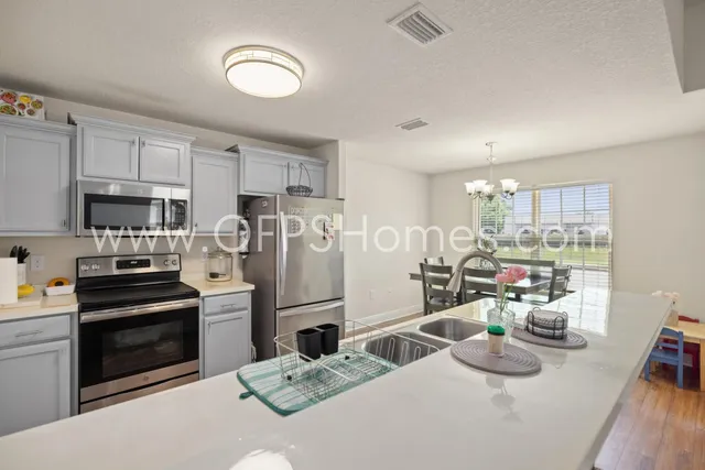 a kitchen with stainless steel appliances kitchen island granite countertop a refrigerator stove microwave and sink