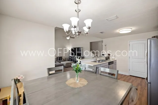 a living room with dining table furniture and a chandelier