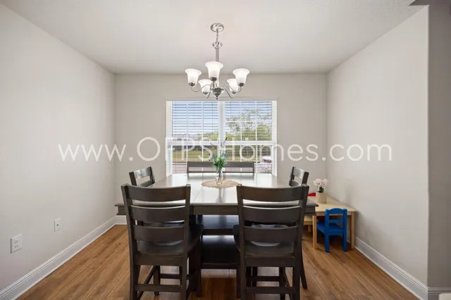 a dining room with furniture a chandelier and wooden floor