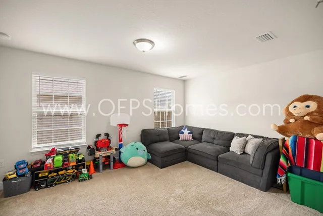 a living room with furniture a flat screen tv and a window