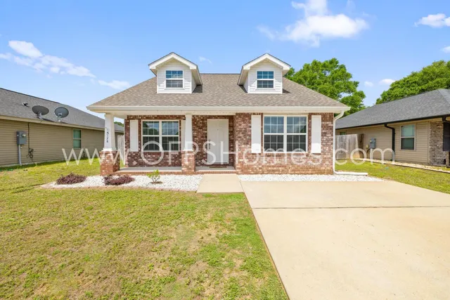 a view of house with swimming pool and a large tree
