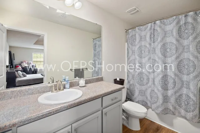 a bathroom with a granite countertop sink mirror vanity and toilet