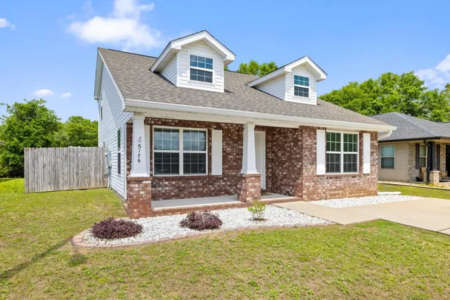 a front view of a house with a yard outdoor seating and garage