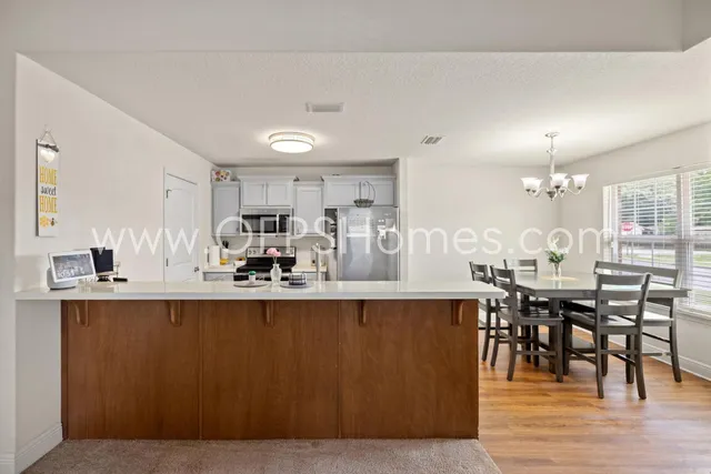 a large kitchen with lots of counter space and dining table