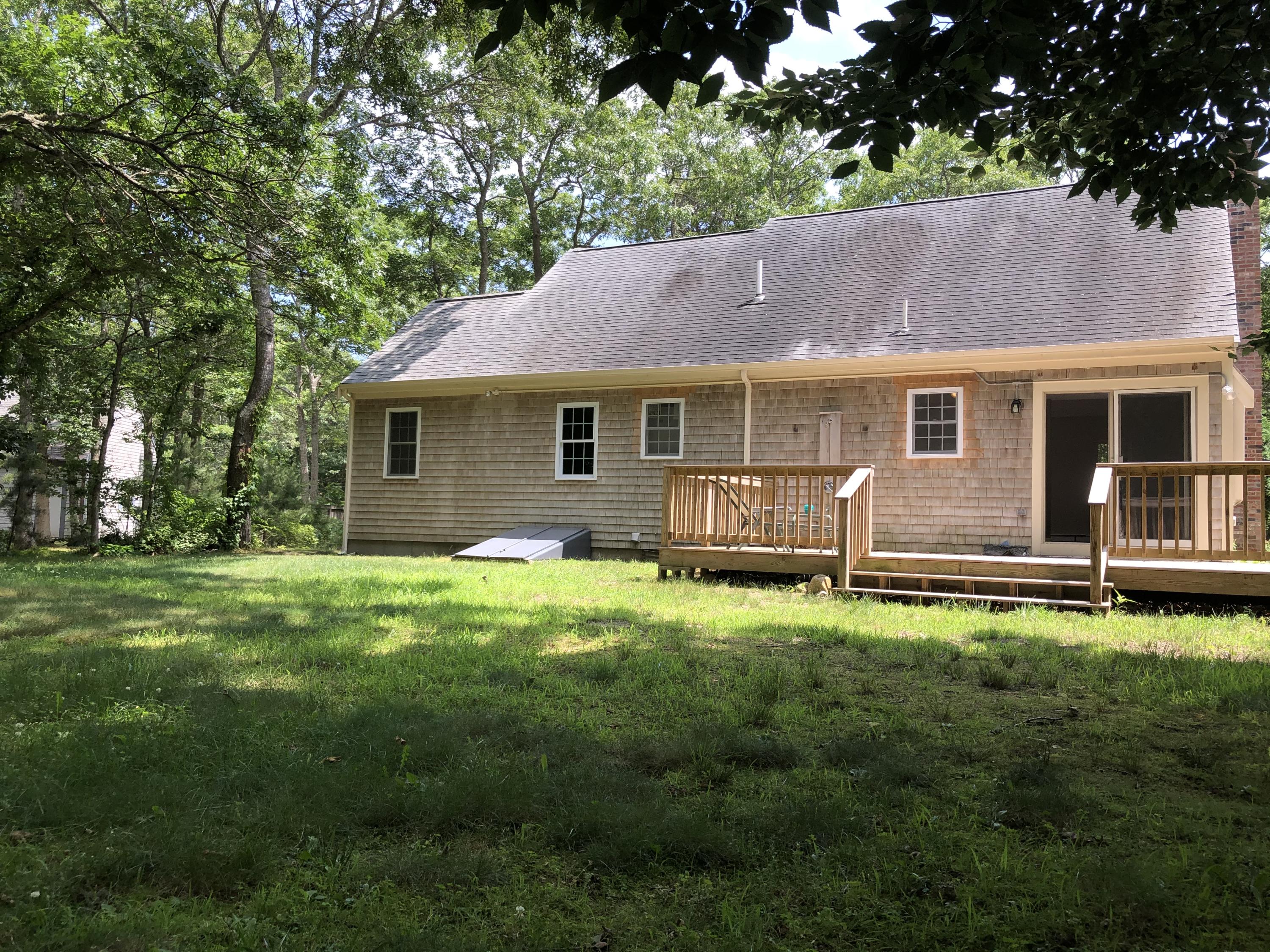 51 Quisset Road Centerville, MA 02632 - Photo 3 of 3 a backyard of a house with table and chairs