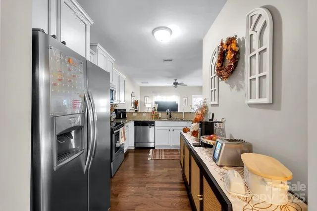 a kitchen with stainless steel appliances granite countertop a refrigerator and a stove top oven