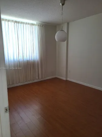 a view of a room with wooden floor and a bathroom