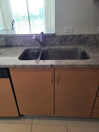 a kitchen with granite countertop a sink and a stove
