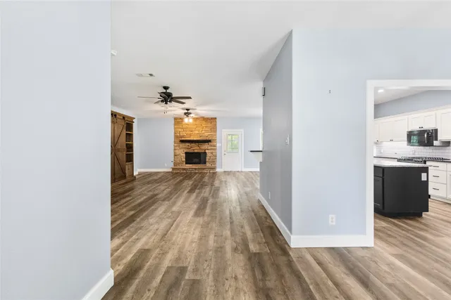 a view of empty room with wooden floor and window