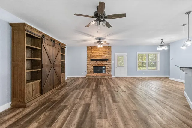 a view of a kitchen with stainless steel appliances granite countertop a stove a sink a refrigerator and white cabinets with wooden floor