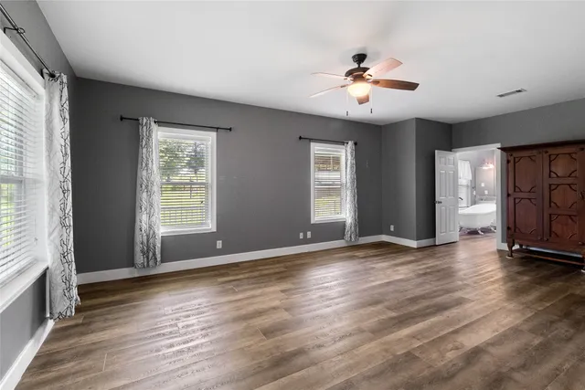 a view of room with window ceiling fan and hardwood floor