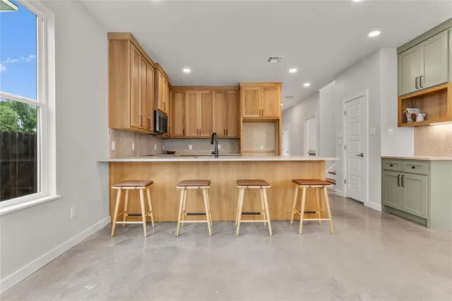 a kitchen with white cabinets and chairs