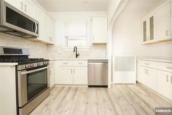 a kitchen with stainless steel appliances a stove microwave and sink