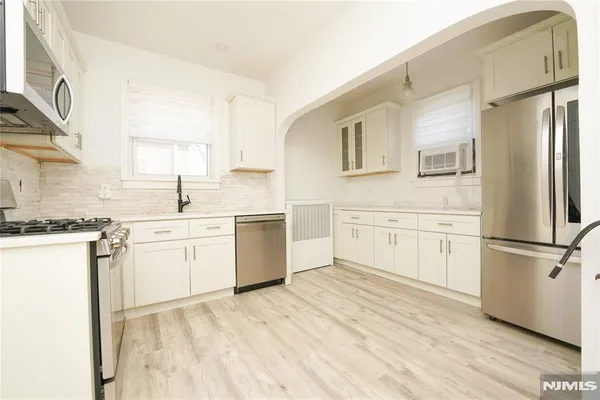 a kitchen with white cabinets sink and white appliances