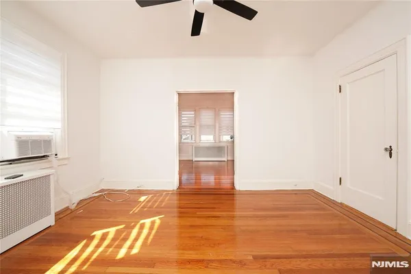 a view of empty room with wooden floor