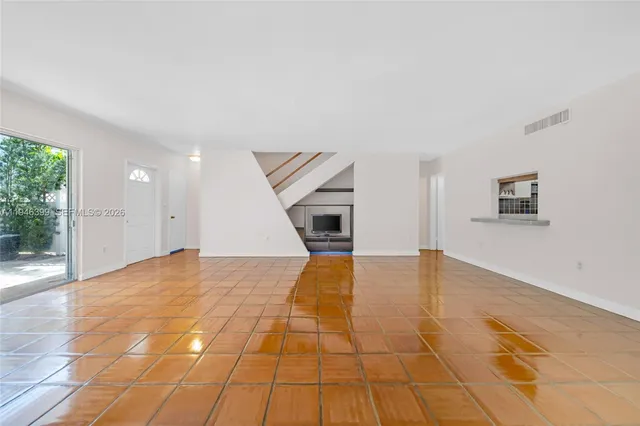 a view of empty room with wooden floor and windows