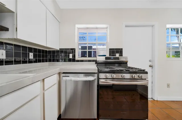 a kitchen with stainless steel appliances granite countertop a stove and a sink