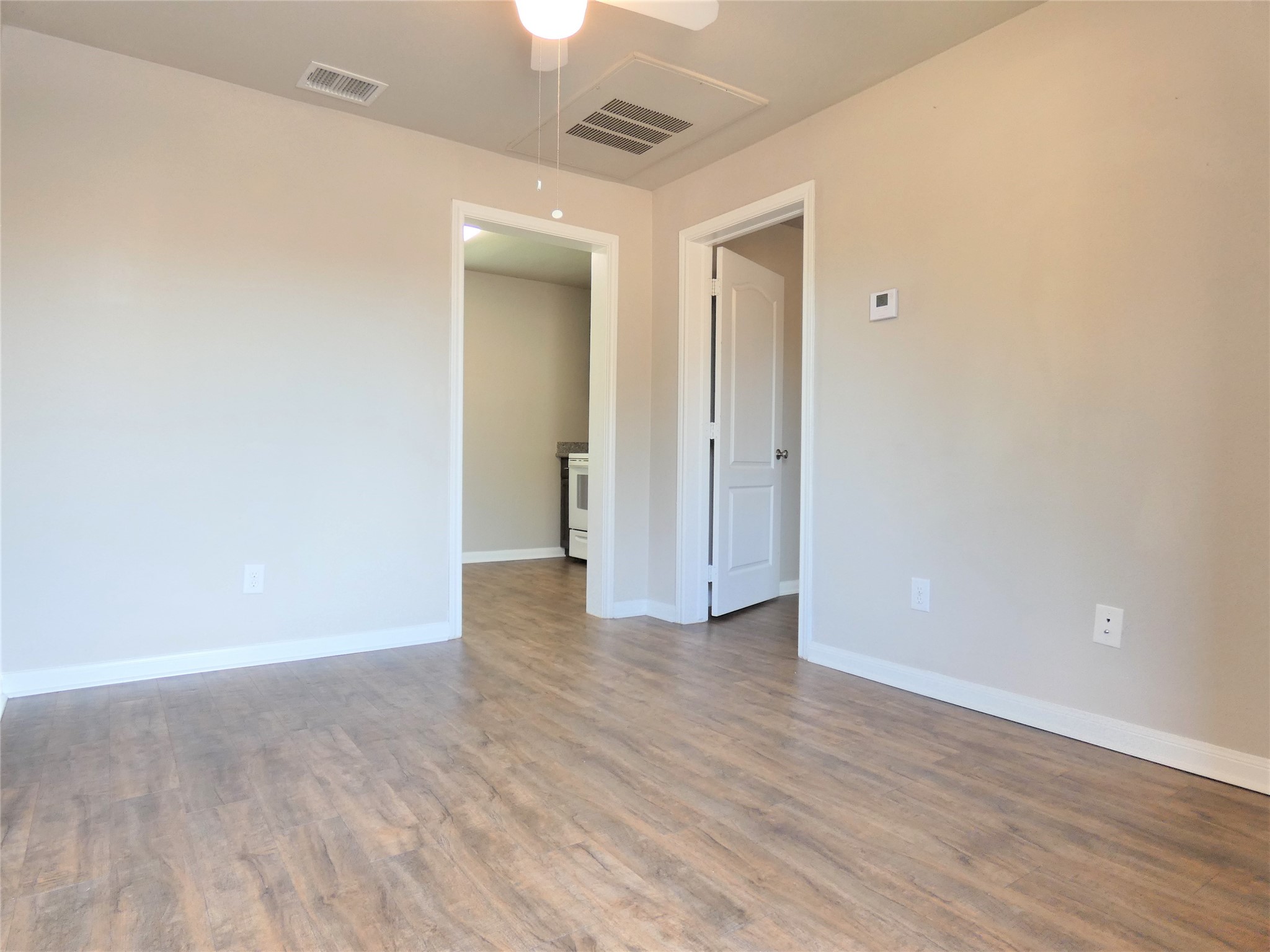 507 Houston Street, Unit 2 Rosenberg, TX 77471 - Photo 2 of 20 an empty room with wooden floor and a ceiling fan