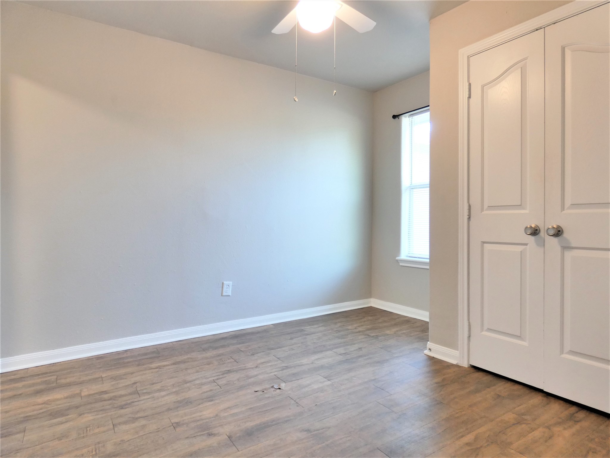 507 Houston Street, Unit 2 Rosenberg, TX 77471 - Photo 7 of 20 an empty room with wooden floor closet and windows