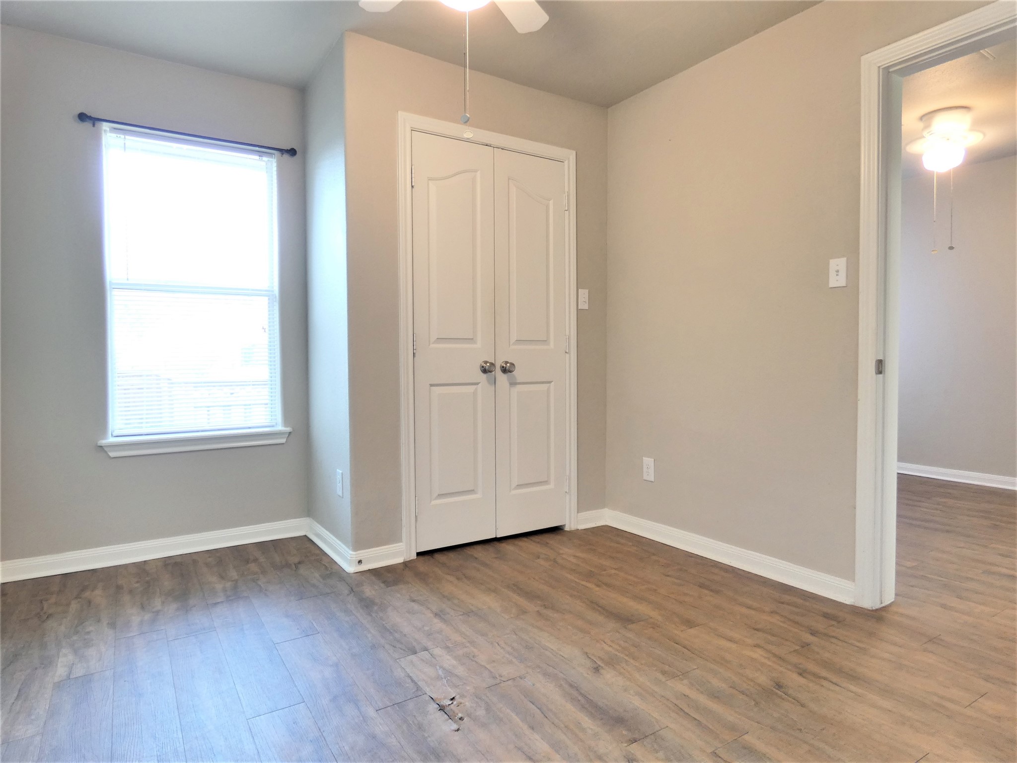 507 Houston Street, Unit 2 Rosenberg, TX 77471 - Photo 10 of 20 an empty room with wooden floor and windows