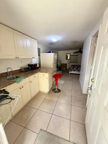 a kitchen with granite countertop a sink a stove and cabinets