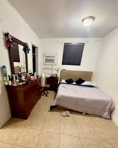 a bedroom with a bed a couch and a large window