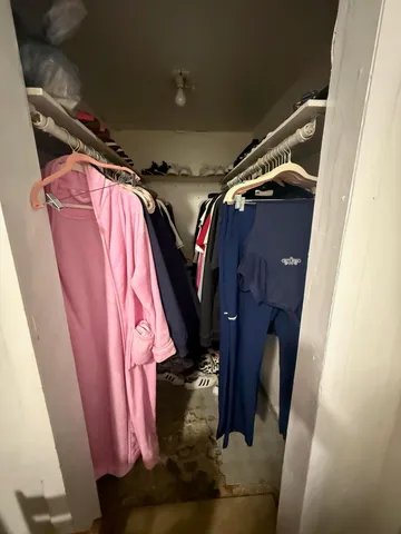 a view of walk in closet with clothes and shoes