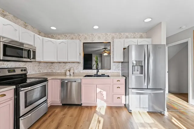 a kitchen with stainless steel appliances a stove a sink and a refrigerator