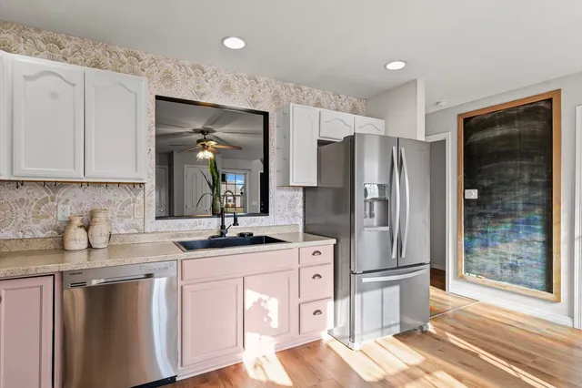 a kitchen with stainless steel appliances granite countertop a refrigerator and a sink