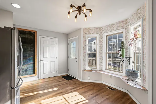 a view of a livingroom with a dinning area hardwood floor and a ceiling fan