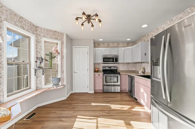 a kitchen with granite countertop a refrigerator cabinets and wooden floor