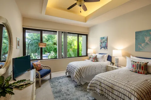 a bedroom with two beds and a large window