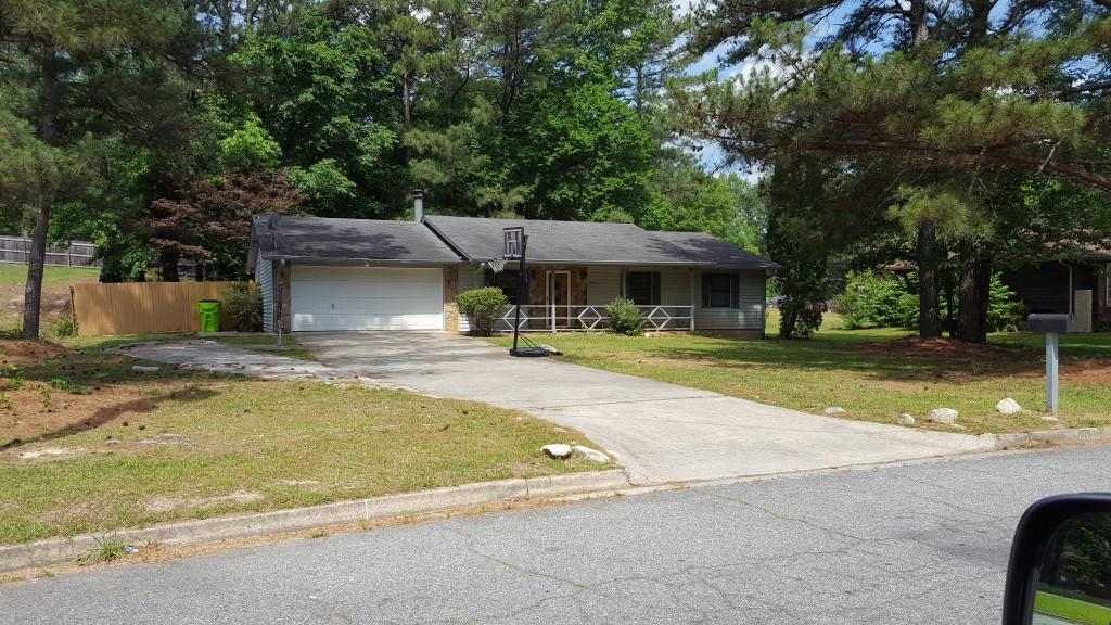 a view of swimming pool with lawn chairs and plants