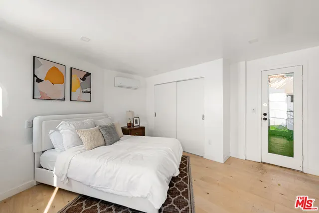 a bedroom with a bed and a painting on the wall