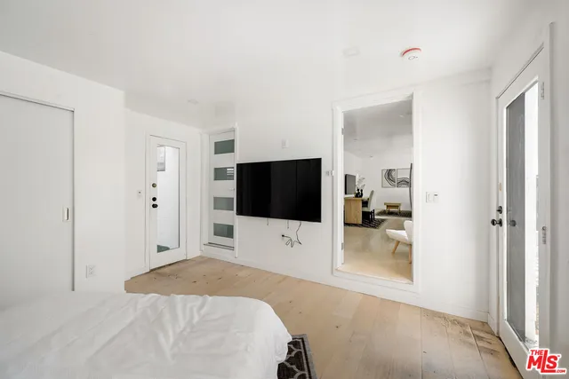 a bedroom with a bed and a flat screen tv