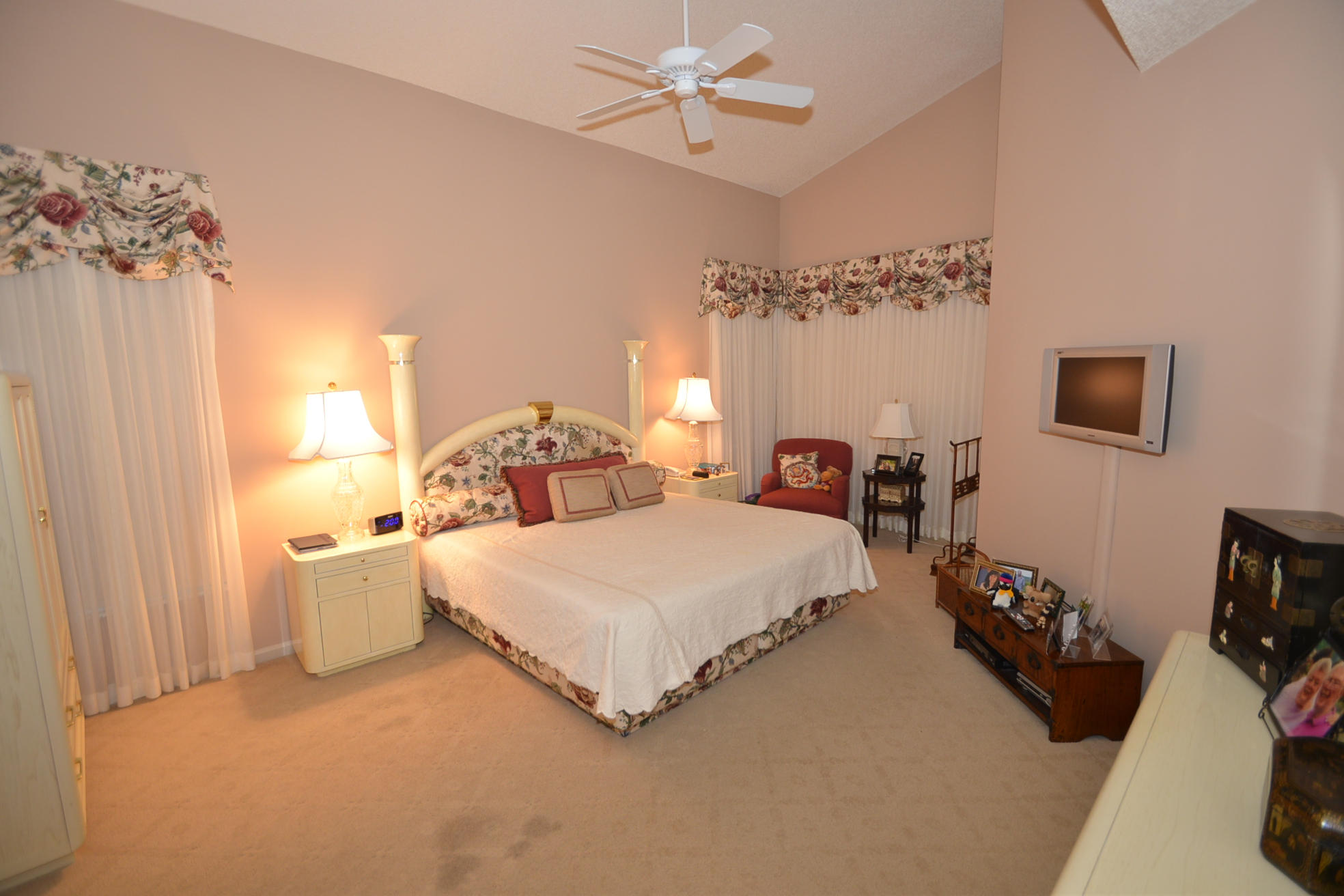 6390 Northwest 24th Avenue Boca Raton, FL 33496 - Photo 11 of 32 a spacious bedroom with a bed and a chandelier
