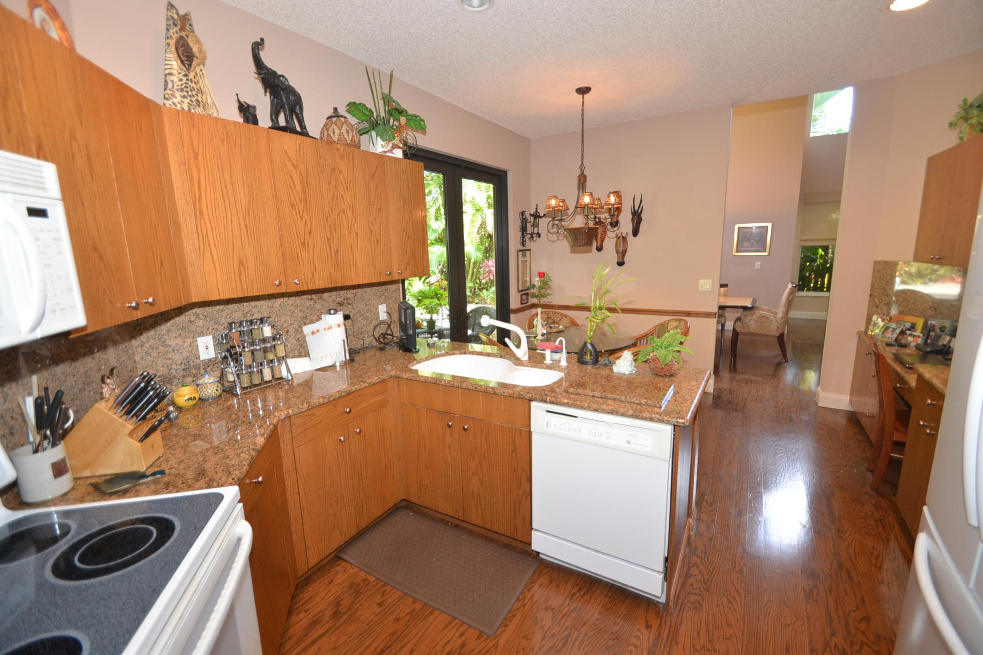 6390 Northwest 24th Avenue Boca Raton, FL 33496 - Photo 21 of 32 a kitchen with a sink stove and wooden cabinets