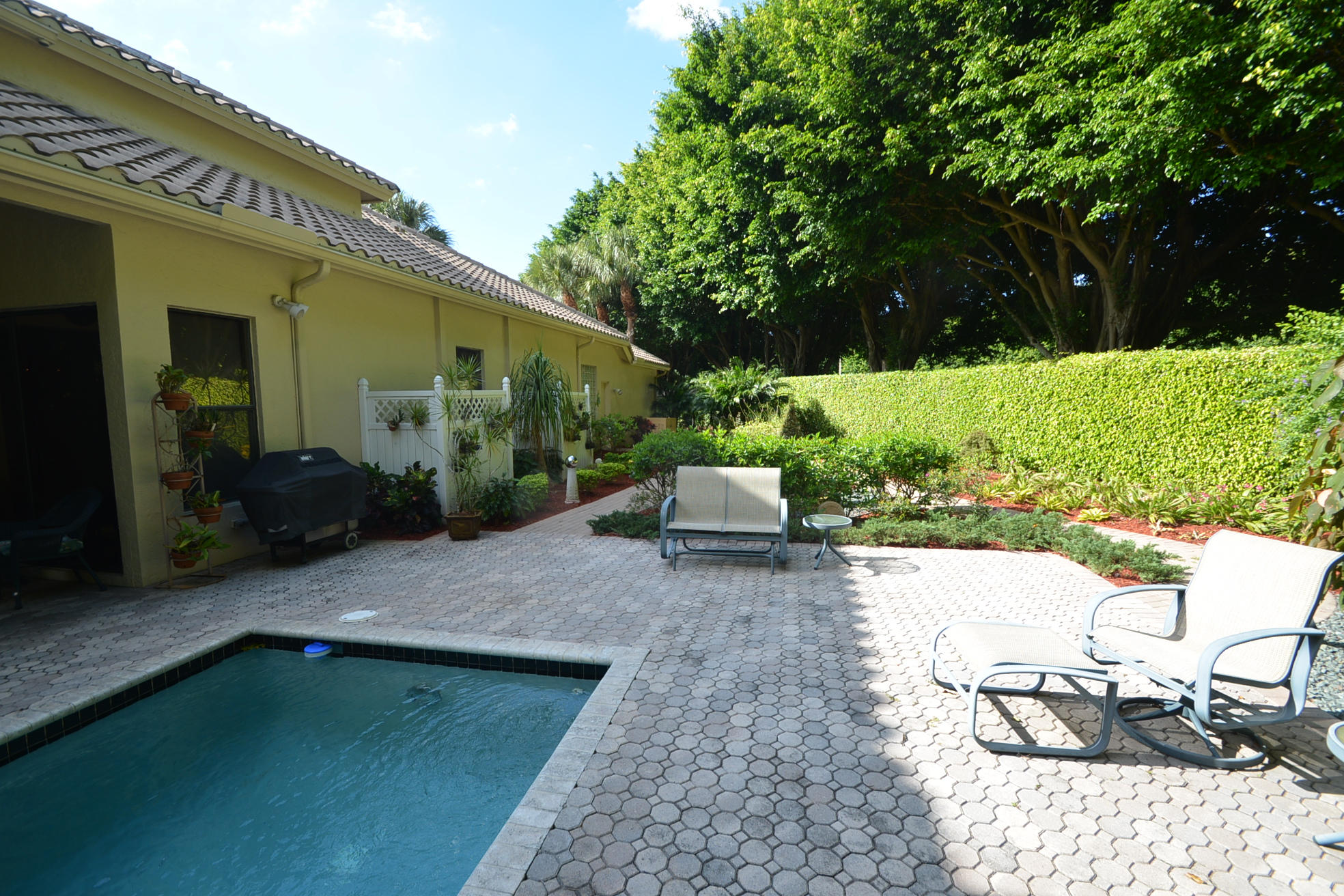 6390 Northwest 24th Avenue Boca Raton, FL 33496 - Photo 32 of 32 a view of a patio with table and chairs potted plants and large tree