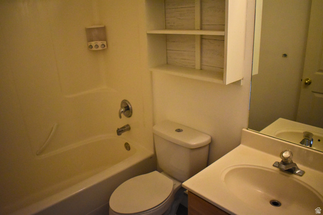 3327 East Windhover Road Eagle Mountain, UT 84005 - Photo 12 of 38 Bathroom featuring a tub/shower combination, white toilet, vanity with integrated sink, and wall-mounted shelving