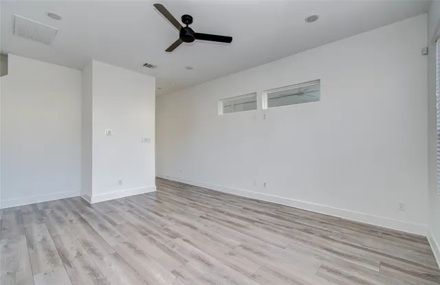 a view of room with wooden floor and ceiling fan